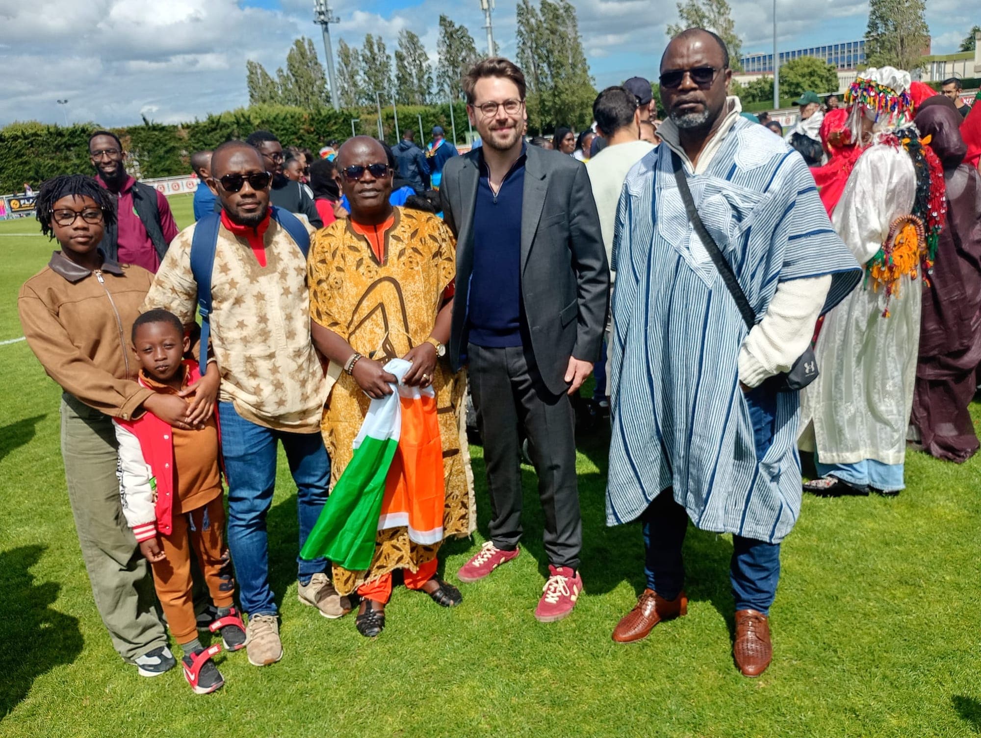 Des membres et amis de l'association, en tenues traditionnelles, avec le drapeau ivoirien lors d'un rassemblement